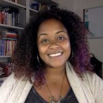 smiling woman in front of bookshelf