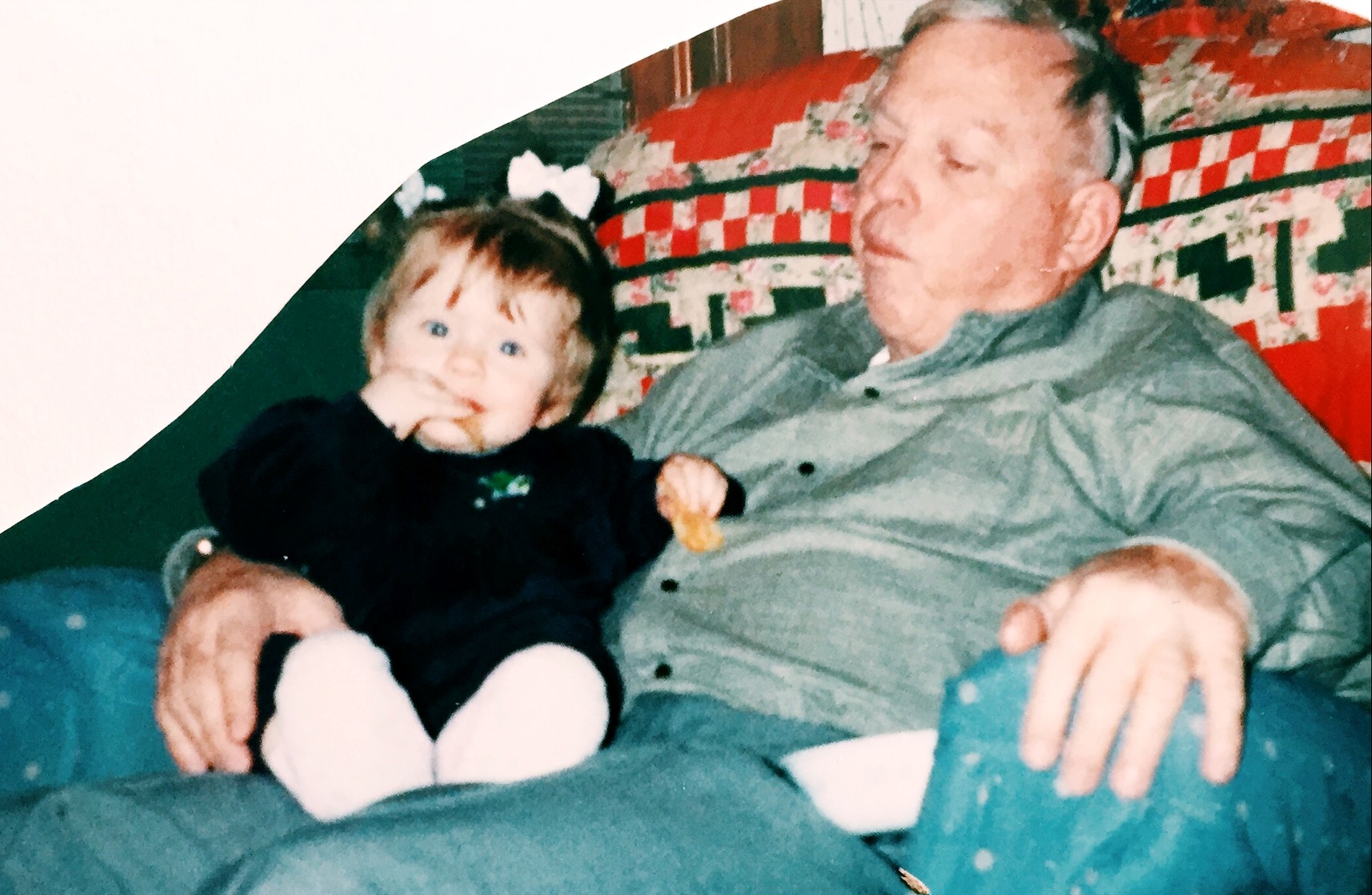 A toddler sitting on her grandpa's lap.