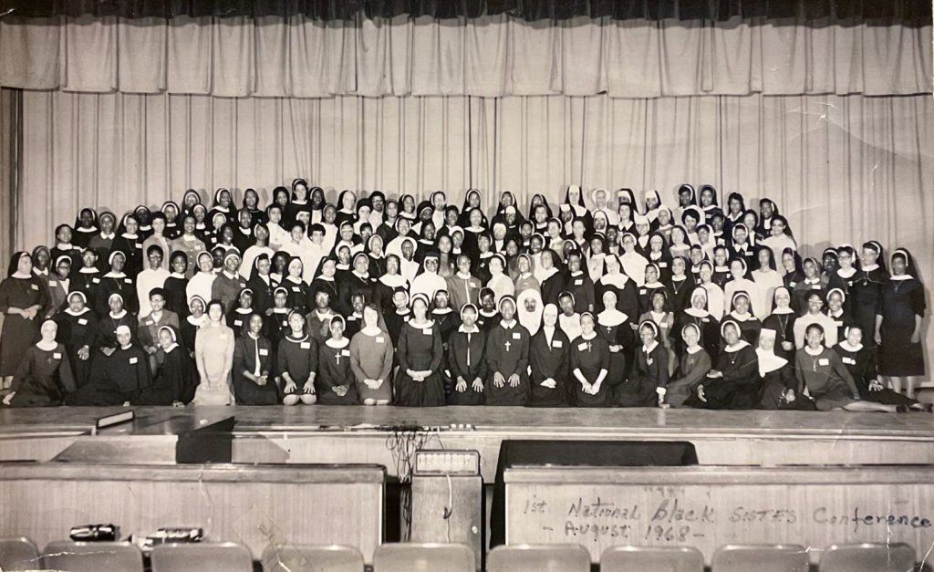 A large group of around 100 women smiling at a camera.